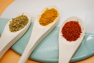Spices in wooden spoons on background. Pepper chilly, basil, curry. Concept of organic food. top view.