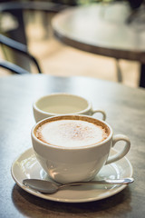 Hot coffee and hot tea place on the marble table in early morning with copyspace, white cup and silver spoon.