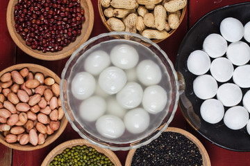 sweet dumplings in bowl on table, ang pow or red packet and gold ingots