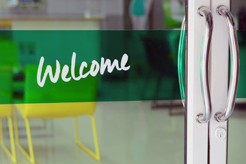 the glasses door with welcome letters on green label at car repair shop