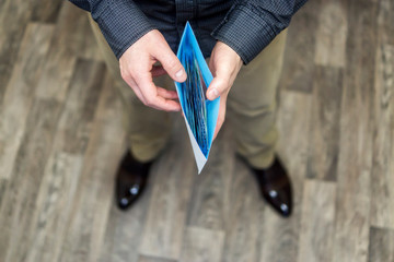 Cash money in envelope in hands of man