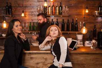 Two young beautiful women talking in the pub