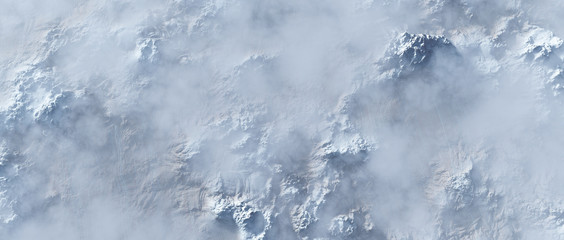 Aerial of rough steep snowy mountains in fog.