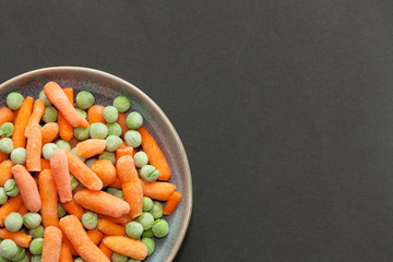 Bowl of frozen green peas and carrot.