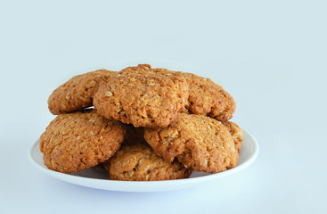 Oatmeal cookies with cereals and seeds on a white plate. White background. Close-up.