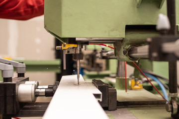 detail of a milling machine making the hole in the lock on an aluminum door