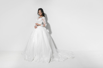 Fototapeta na wymiar Beautiful young bride in white studio