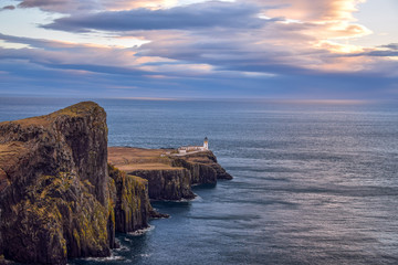 view of neist point with lighthouse in sunset and shiny clouds, isle of skye, Scotland, UK