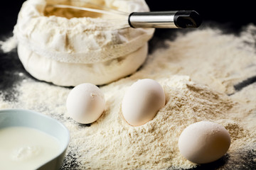 Close up of eggs on pile of flour.