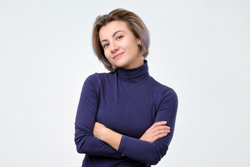 Smiling woman in blue clothes with crossed arms looking and smiling