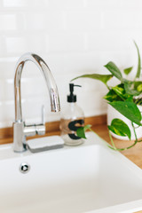 White sink soap dispenser wooden countertop and white ceramic brick tile background