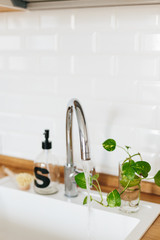White sink soap dispenser wooden countertop and white ceramic brick tile background