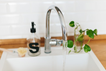 White sink soap dispenser wooden countertop and white ceramic brick tile background