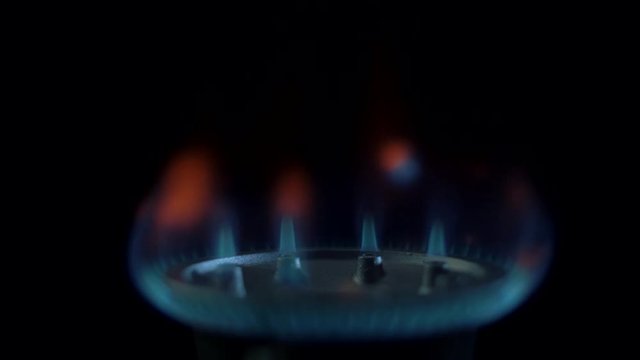Natural gas is lit by the blue flame of a gas stove in the kitchen
