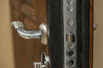 Wooden door. Internal lock design. Keyhole. Metal door handle. Anti-burglar armored door. Metal...