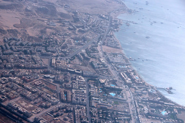 Aerial city view with houses, buildings, seaside in Egypt. Flying above country