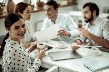 Positive delighted brunette woman looking at camera
