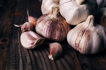 Garlic cloves on rustic wooden table. Vitamin healthy food spice image. Spicy cooking ingredient picture.