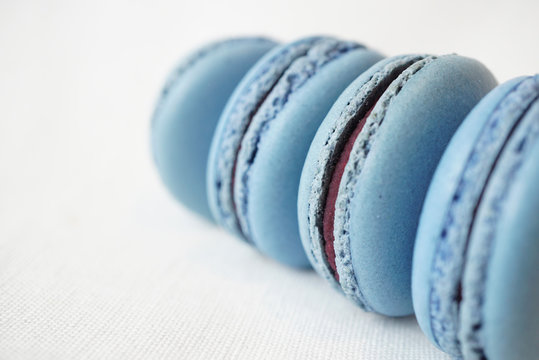 Blue macarons with violet or purple cream on white cloth