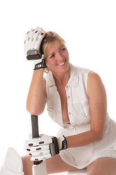 woman cricketer in a revealing dress seated with her gloved hand resting on her head