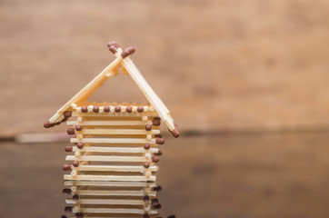 Wooden house from matches - model of safe living with insurance
