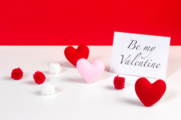 Be my Valentine card decorated with heart shaped fabrics and pom pom on red and white background