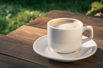 Coffee cup top view on wooden table background. Beautiful morning, outdiir, spring sun light.
