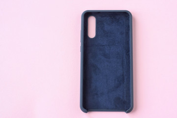 New blue leather case with selective focus for mobile phone on neutral pink background. Cellphone...