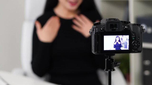 Young vloger making her video for blog. Talking with camera.
