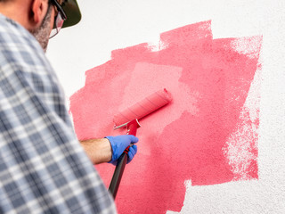 Professional house painter at work painting the wall © francescomou