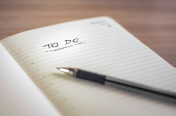 Notebook with a To Do title written by hand and a black pen. .