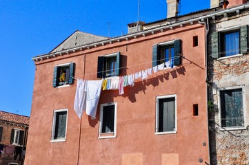 Non touristic part of Venice with empty silence colorful buildings, windows, streets and boats