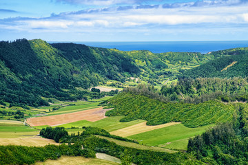 Fototapeta na wymiar Landscape on Sao Miguel island of Azores, Portugal, with green mountains and Atlantic Ocean on skyline.