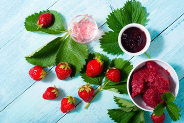 strawberry fruits with jelly, jam, marmalade on old blue table
