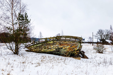 in the winter, the remains of an old boat stand on the field