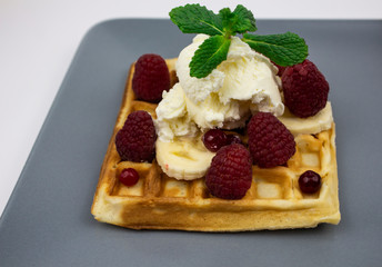 Waffles with ice cream, strawberries, mint, kiwi, mendarine, background