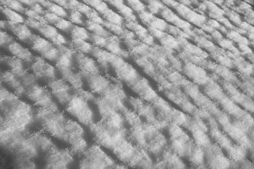 Diagonal wavy texture of the snow dunes under the sun - winter background