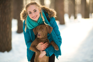 beautiful young girl hugging her dog in the park