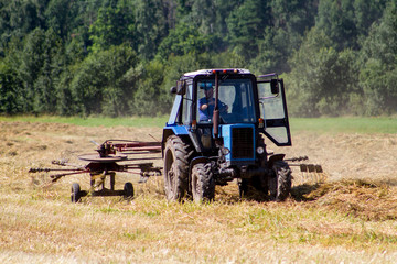 Tractor removes the straw after the grain harvest