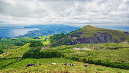 Green landscape of Sao Miguel island of Azores, Portugal, with cloudy sky.