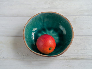 An orange in a bowl on a table