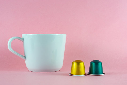 coffee capsules and cup in on light  pink background