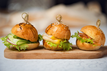 Miniburgers for the buffet on the kitchen board. Restaurant menu.