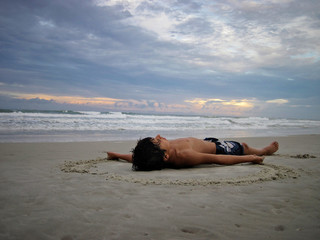 relaxed boy lying on a beach