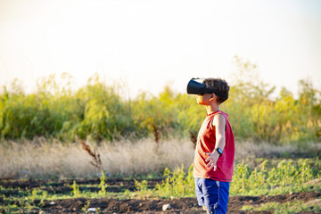 The boy in 3D glasses on the street in the park.