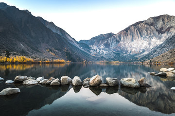 Long exposure sunrise photo of Convict Lake, an alpine lake in the Sierra nevada mountains of California, with alpenglow on the mountain peak on a fall morning