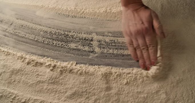 Hand moving on table of Flour 4K food background abstract.