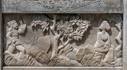 Stone relief panel showing tradional Chinese scene. Man, woman and tree,