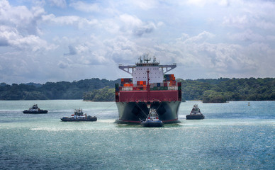 January 28, 2019, Panama Canal, Panama. Tug boats pulling large ship to enter locks of the Panama...