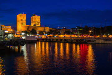 Night view of Oslo city hall (Radhus) a popular landmark of the city, facing the harbour and Oslofjord, Oslo, Norway
